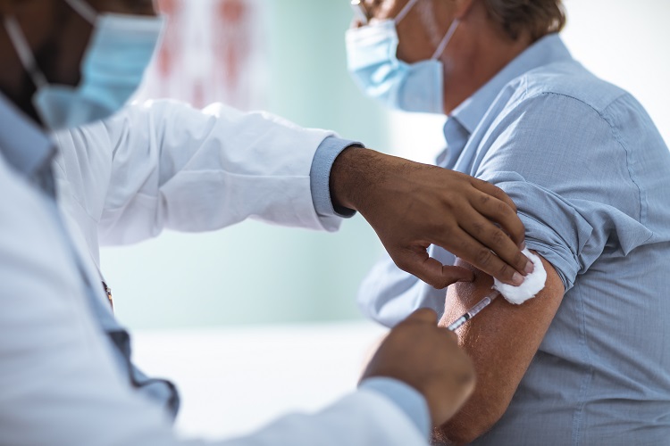 Close up of a mature man taking a vaccine in his doctors office